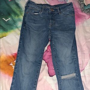 tight, high-waisted blue jeans with rip on knee
